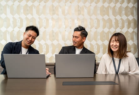 3人でパソコンを見て会議している様子